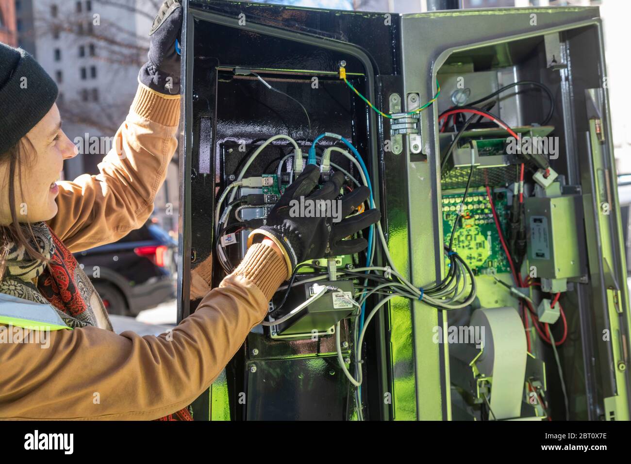 Detroit, Michigan - EIN Arbeiter untersucht die computergesteuerte Leitstelle in der Andockstation von Detroits MoGo-Fahrradverleihsystem. Stockfoto