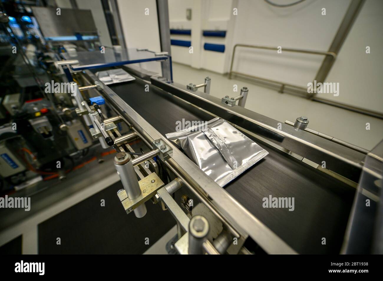 Ein Covid-19-Antikörpertestkit in einer versiegelten Folie wird entlang eines Förderbandes entlang der Produktionslinie im Ortho Clinical Diagnostics (OCD)-Testlabor in Pencoed in Wales transportiert. Stockfoto