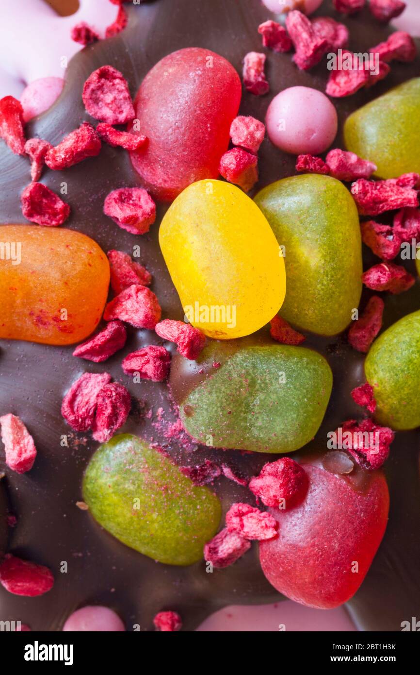 Gefriergetrocknete Himbeeren und Gelee-Bohnen Dekorationen auf dem fruchtigen Osterei der M&S-Ostersonntage Stockfoto