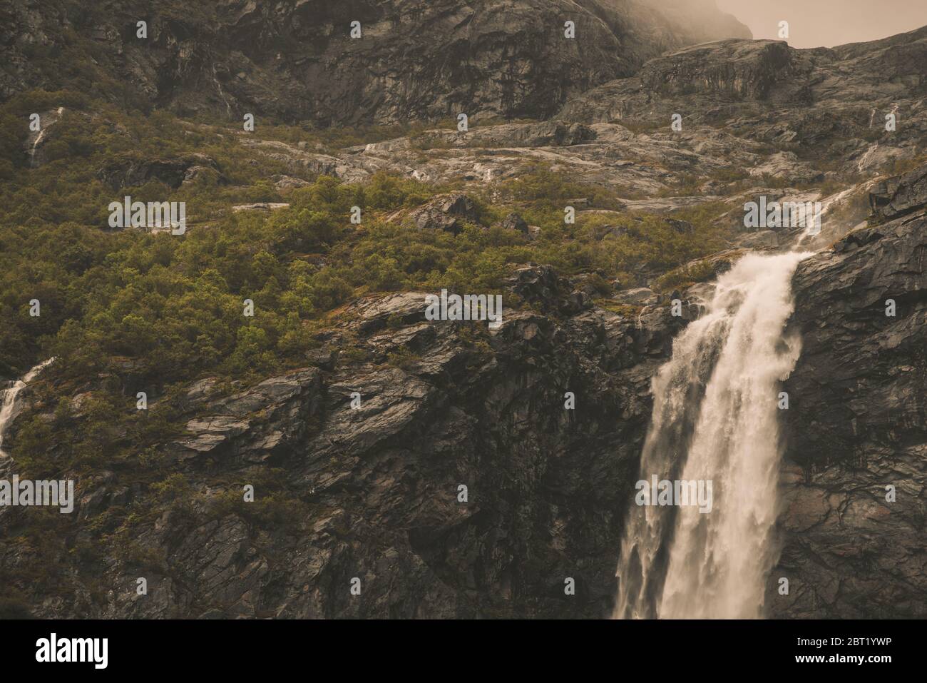 Luftaufnahme Eines Robusten Hohen Wasserfalls Mit Felsbrocken Und Kurzer Grüner Bürste In Den Norwegischen Bergen. Stockfoto