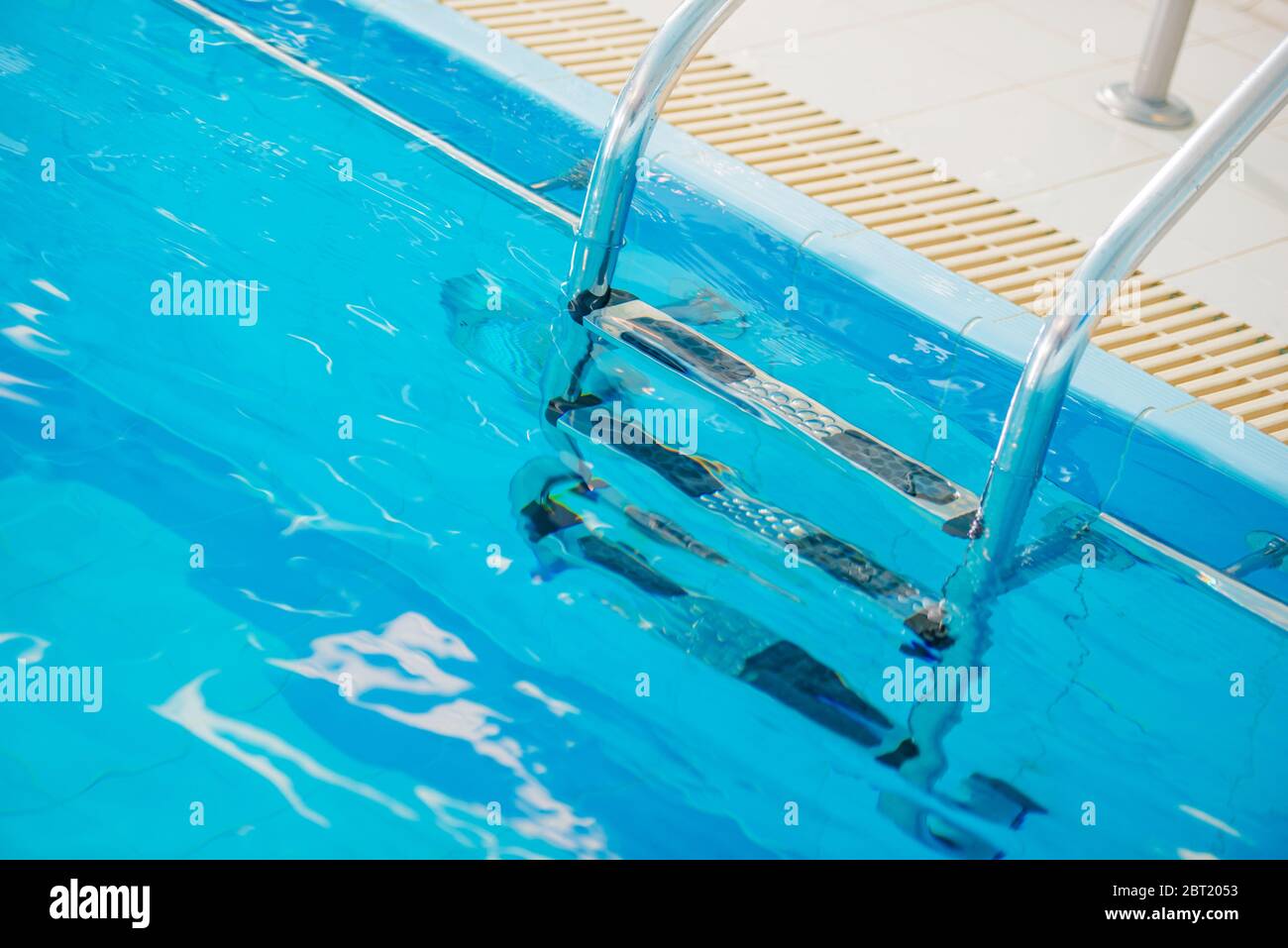 Nahaufnahme Der Silver Stainelss Stahl Pool Leiter In Sauberem Schwimmbad Wasser Getaucht. Stockfoto