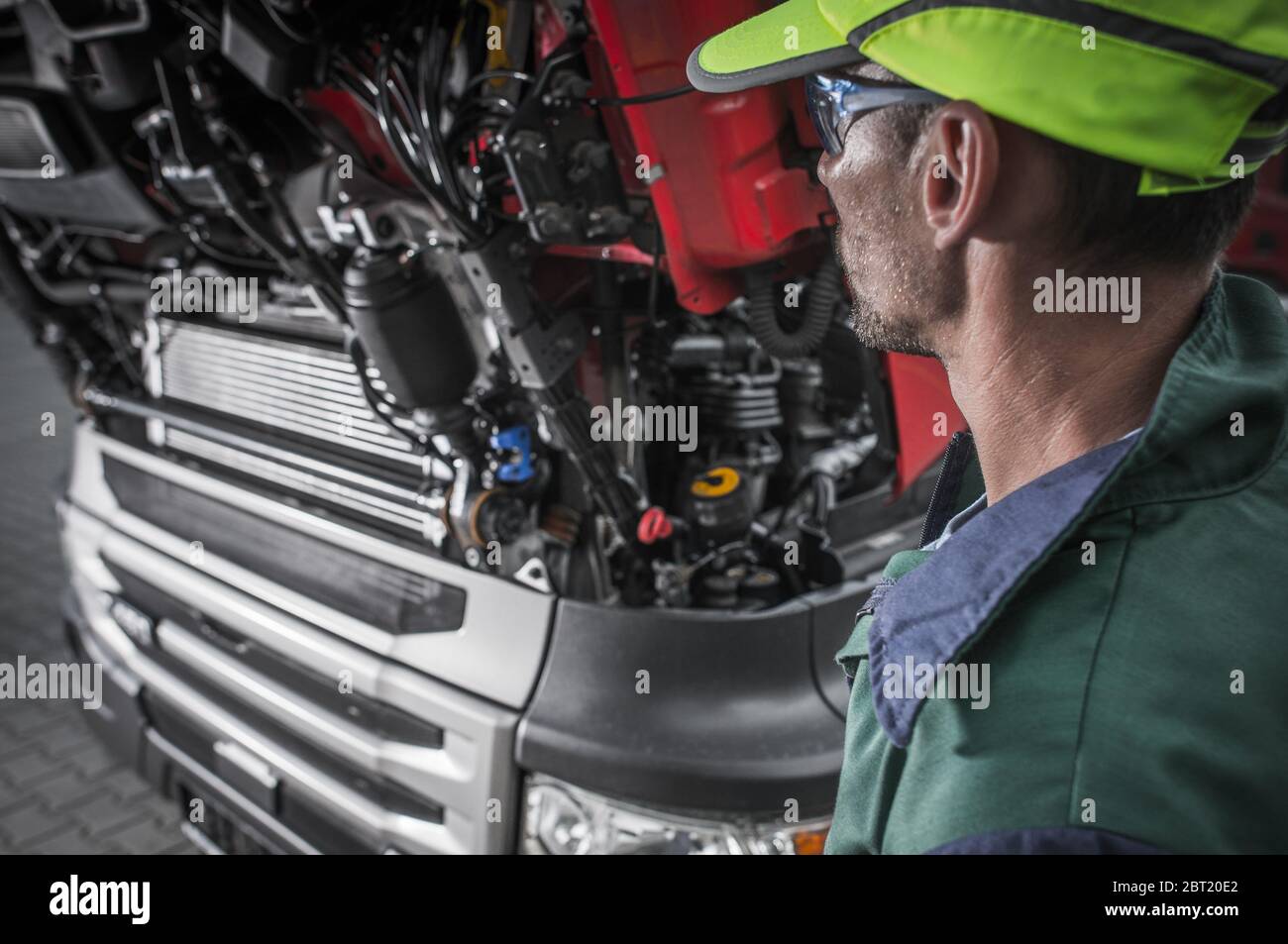 Männlicher Techniker, Der Sich Die Offene Haube Des Fahrzeugs In Der Autowerkstatt Anschaut. Stockfoto