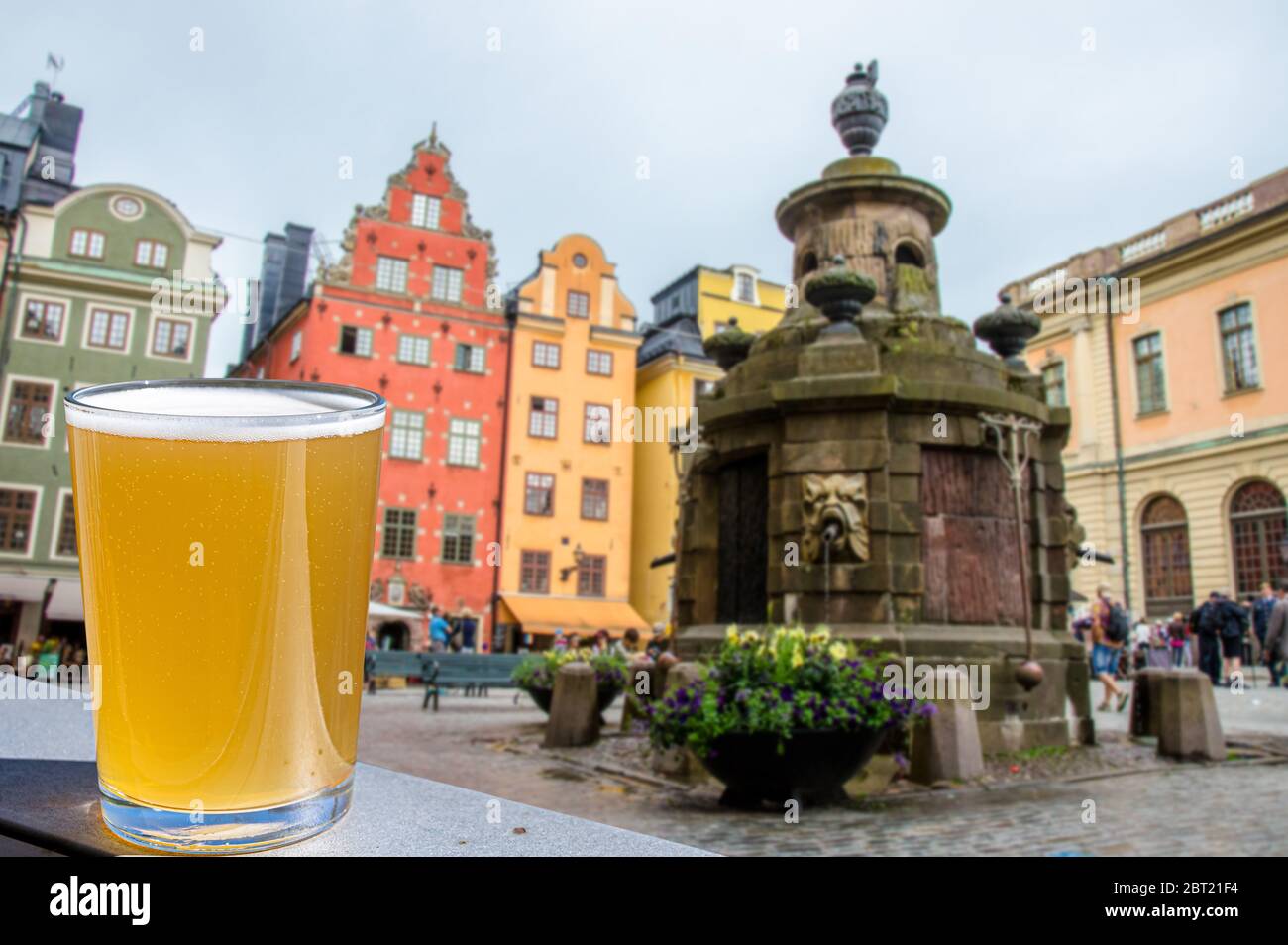 Ein Glas Bier vor dem Blick auf das Stadtzentrum von Stockholm auf Gamla Stan, Schweden. Stortorget in der Altstadt, dem ältesten Platz in Stockholm Stockfoto