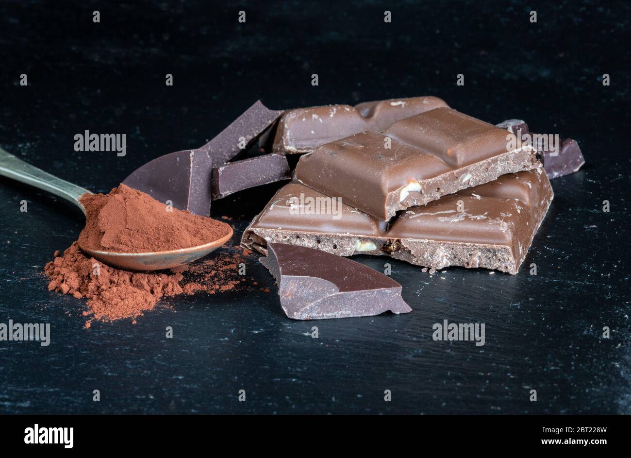 Zerbrochene Schokolade mit Kakaopulver Stockfoto