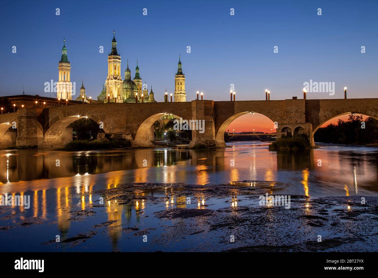 Basilika El Pilar und die römische Brücke über den Fluss Ebro. Blick in die Dämmerung. Zaragoza, Spanien. Stockfoto