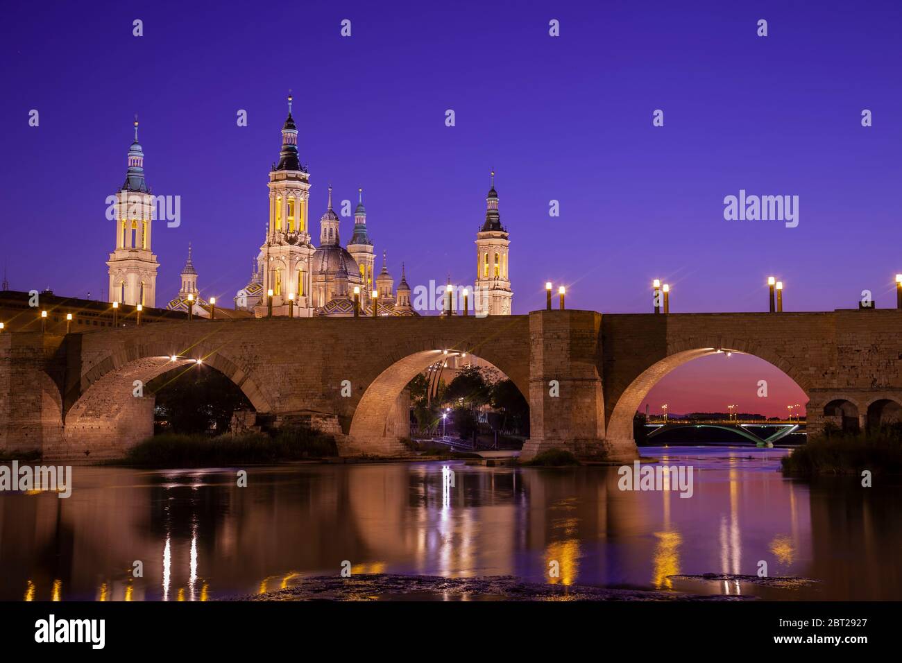 Basilika El Pilar und die römische Brücke über den Fluss Ebro. Blick in die Dämmerung. Zaragoza, Spanien. Stockfoto