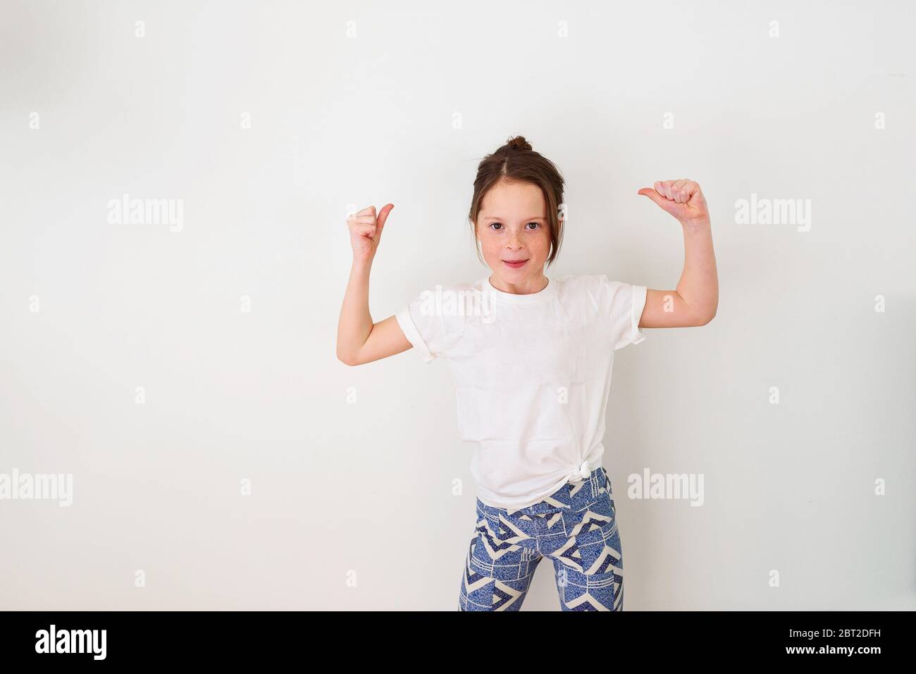 Porträt eines Mädchens, das ihre Muskeln spannt Stockfoto