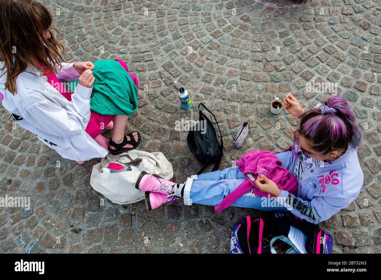Eine Gruppe von Klimaaktivisten sieht man beim Nähen gebrauchter Kleidung,  während sie auf dem Boden sitzen.Extinction Rebellion Nederland  organisierte eine XR-Modeaktion, um eine Alternative zur rasanten Fast  Fashion-Industrie zu zeigen. Rund zwanzig