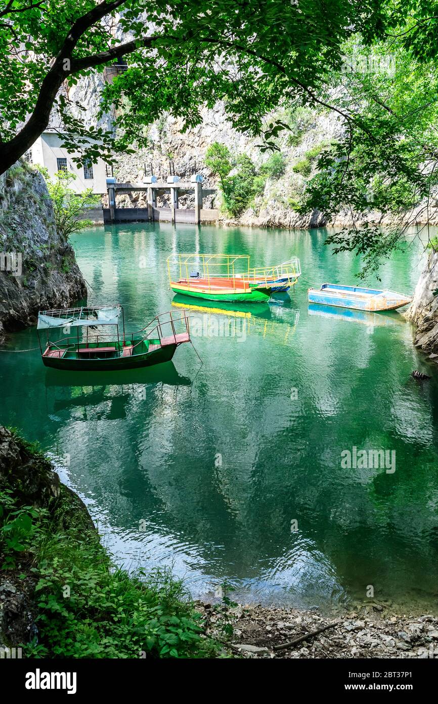 Alte schroffe und bunte Boote dockten in der kleinen Bucht am Matka Canyon, Skopje, Mazedonien Stockfoto