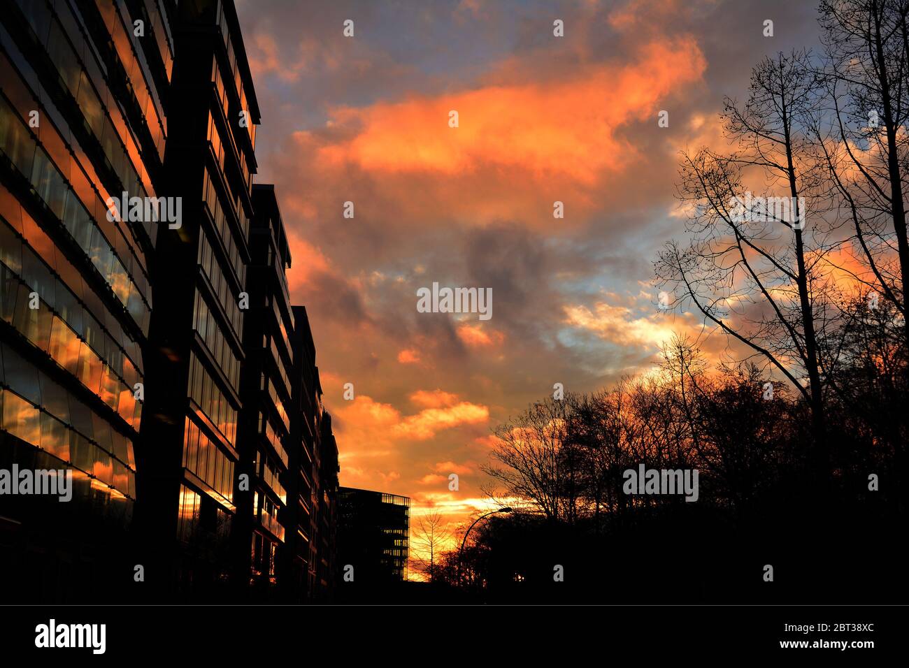 Ein feuriger Sonnenuntergang spiegelte sich auf einem Gebäude in einer Stadt wider Stockfoto