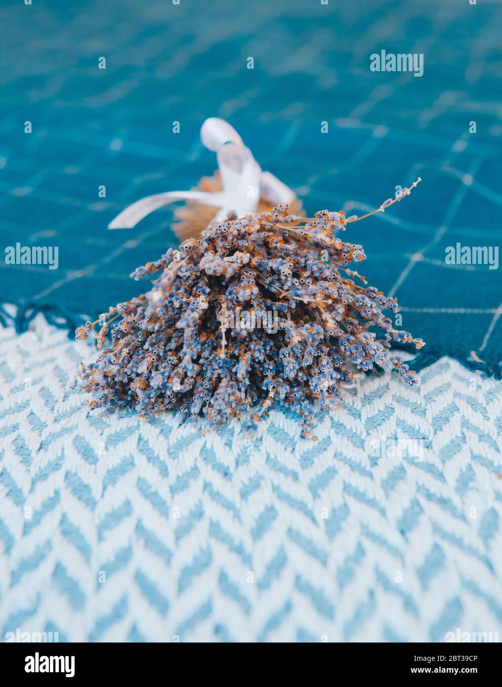 Ein Bündel trockener Lavendel auf einem Hintergrund von blau gewebten Bettüberwürfen Stockfoto