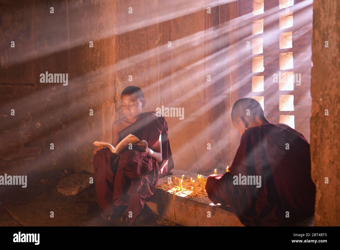 Novize Mönche sitzen in einem Tempel Lesung, Bagan, Mandalay, Myanmar Stockfoto