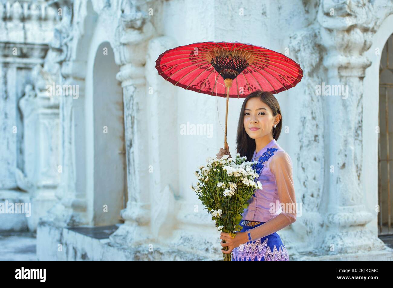 Porträt einer schönen Frau mit Blumen im Shwe Nan Daw Kloster, Mandalay, Myanmar Stockfoto