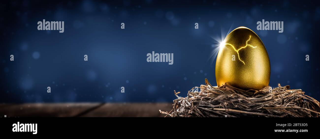 Glänzendes Golden Nest Ei Auf Holztisch Öffnen Mit Lichtburst - Investment Reife Konzept Stockfoto