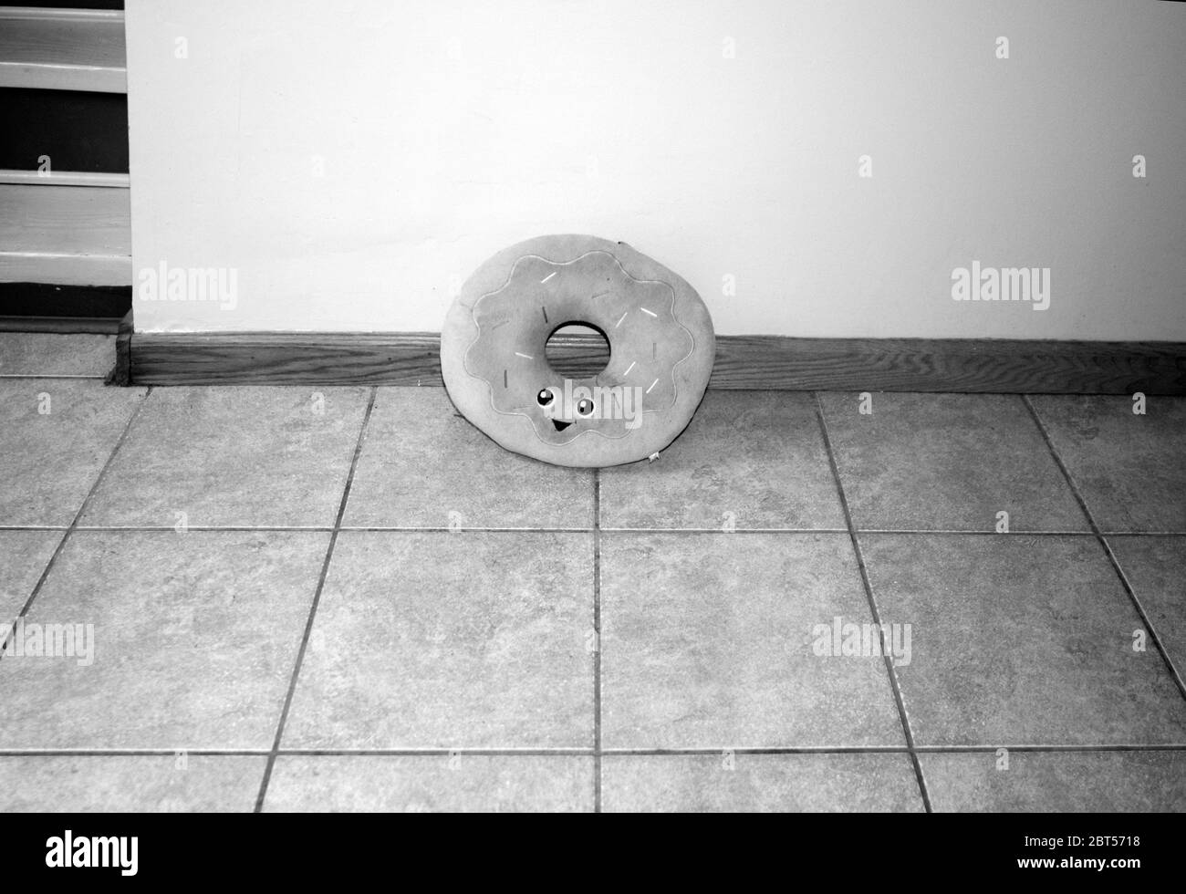 Schwarz-Weiß-Foto eines Donut-Kissens mit lächelndem Gesicht. Stockfoto