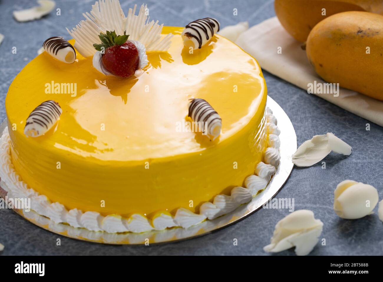 Frischer Käsekuchen mit Mangofrucht und Glasur, die Flan-Hülle aus Keksbröseln. Glasierte Erdbeeren Beläge Stockfoto