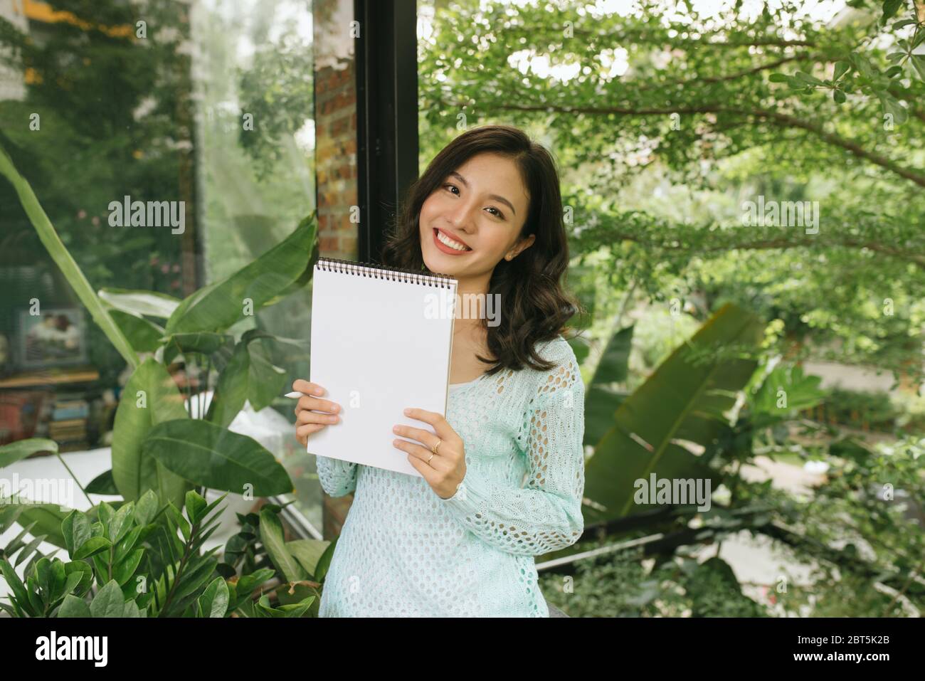 Portrait von glücklichen asiatischen Frau, in Notepad. Stockfoto