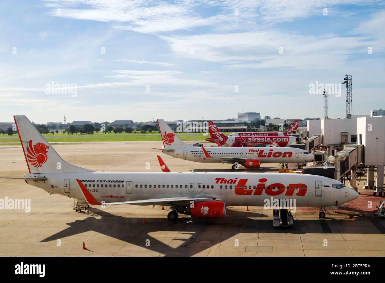 Bangkok, Thailand - 13. April 2020: Lion Air und AirAsia Flugzeuge in Parkbucht am Flughafen Terminal nach Flugstornierung während Coronavirus p Stockfoto