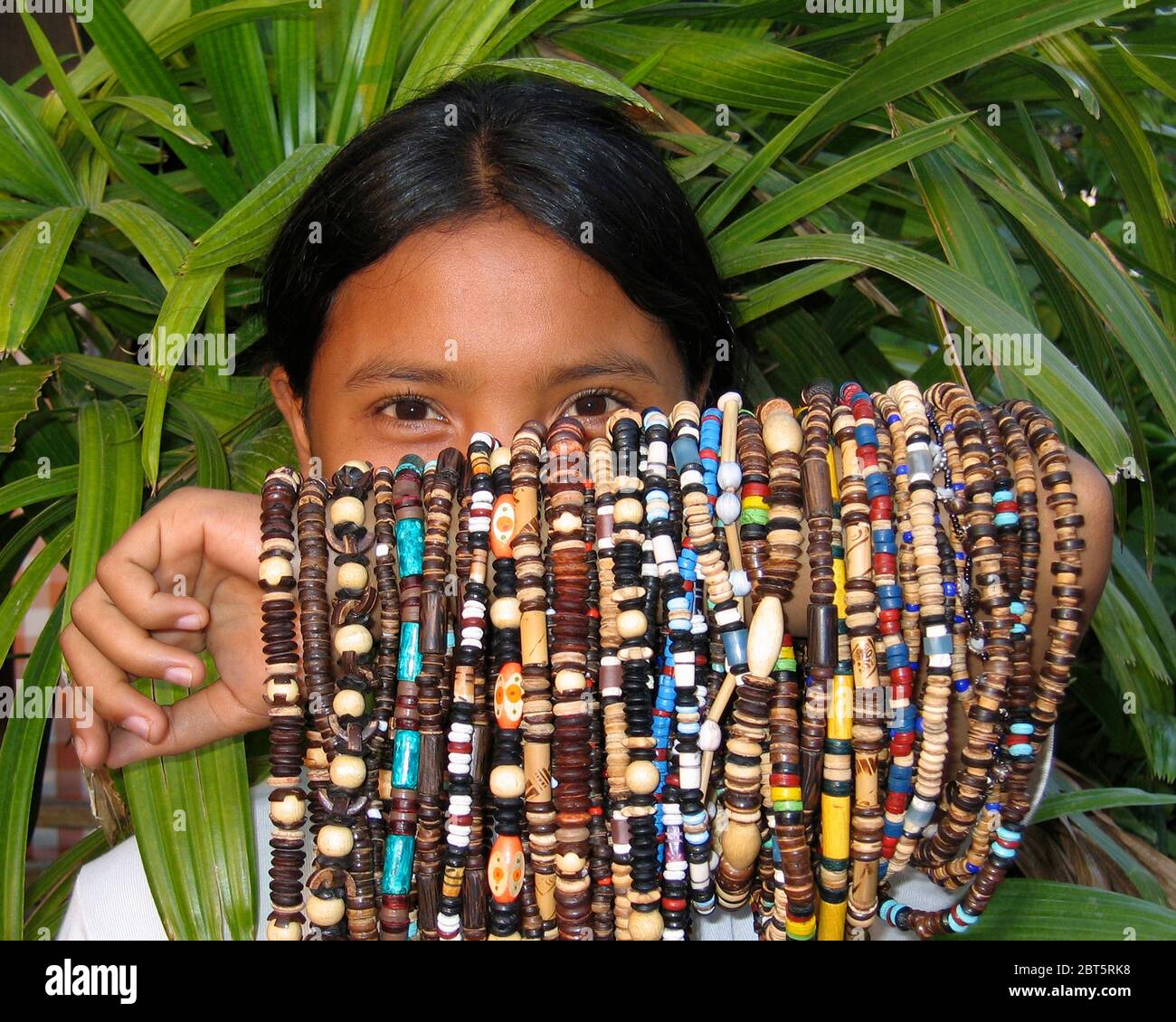 Junge Mädchen, die Armbänder und Perlen für Touristen mit vielen Artikeln  zum Verkauf über ihren Arm tanah Lot bali indonesien drapiert 2004  Stockfotografie - Alamy
