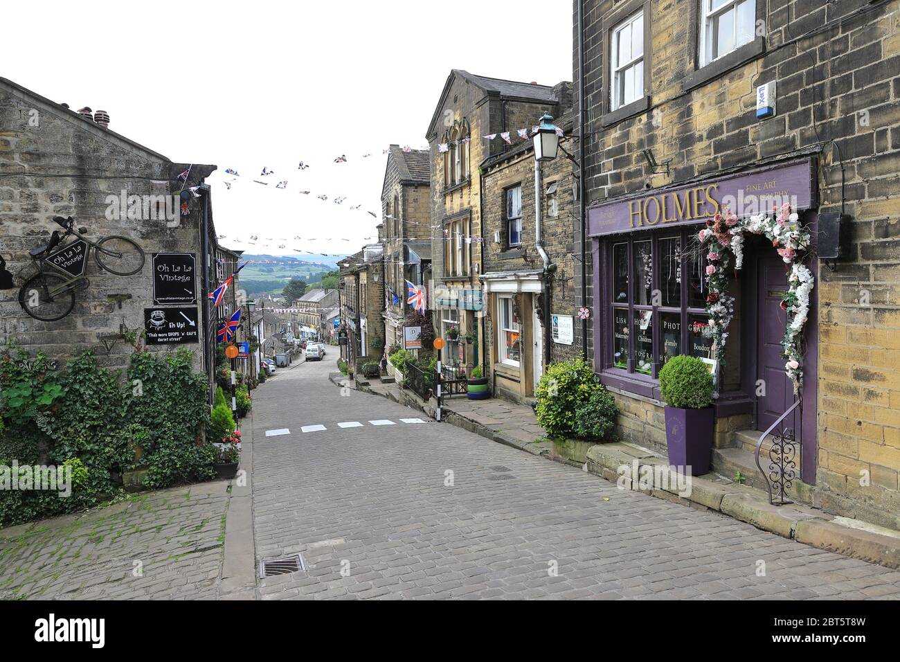 Die Aussicht auf die gepflasterte Hauptstraße in Haworth, West Yorkshire. Haworth war die Heimat der Bronte Schwestern und ist ein beliebtes Touristenziel Stockfoto