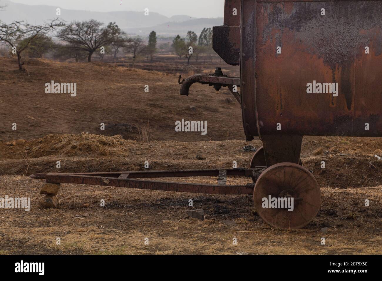 Ein mobiler Teerschmelzofen mit einem Tank oben, um den Teer oder Bitumen zu schmelzen und ein Ofen unten, um Holzstämme zu verbrennen. Stockfoto