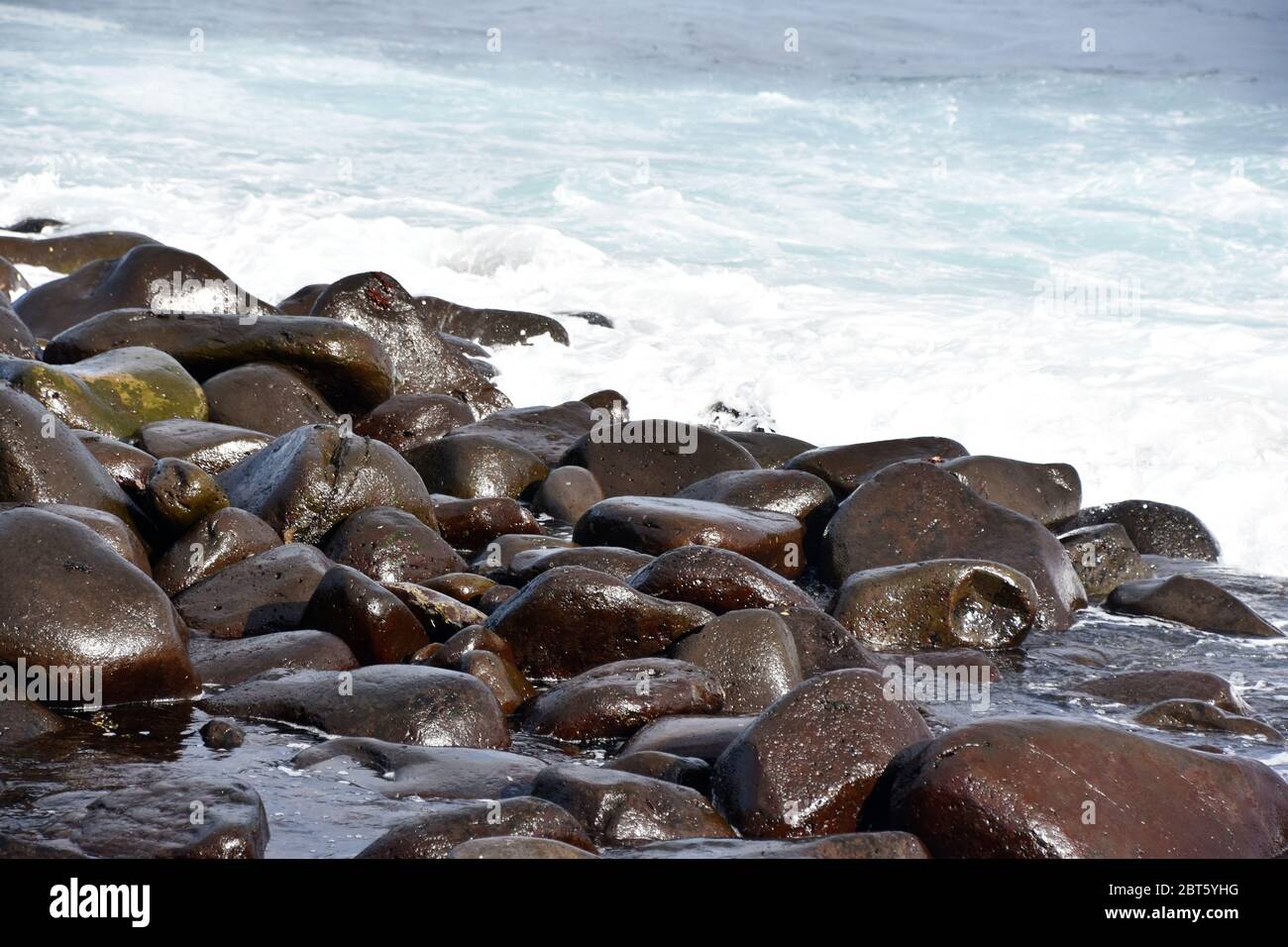 Wellen brechen an steinigen felsigen Strand Küste Stockfoto