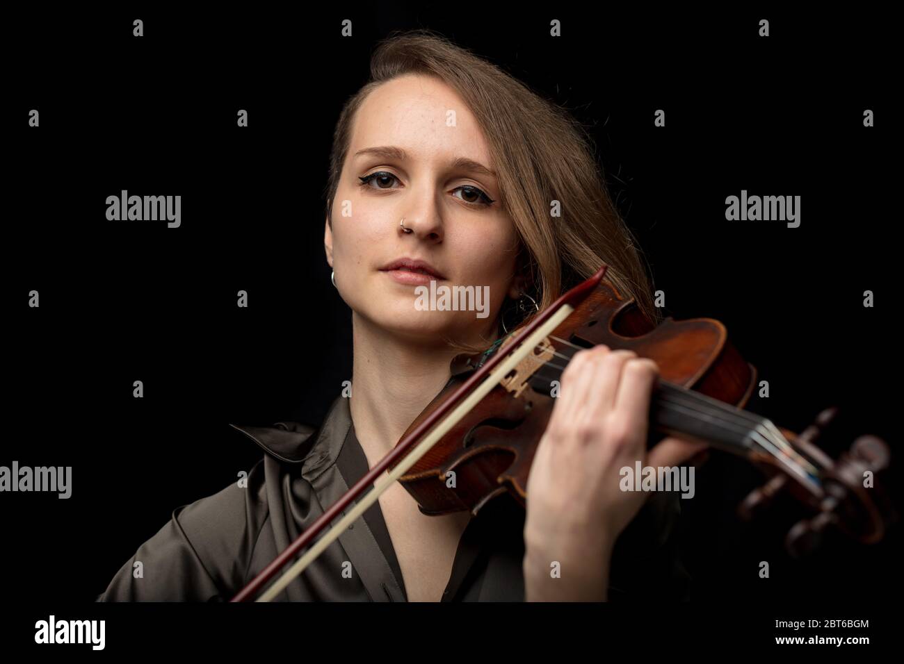Ernst junge Geigerin oder Musikerin spielt auf einer antiken Barockgeige während einer klassischen Musik-Performance in einem Kopf und Schultern frontal p Stockfoto