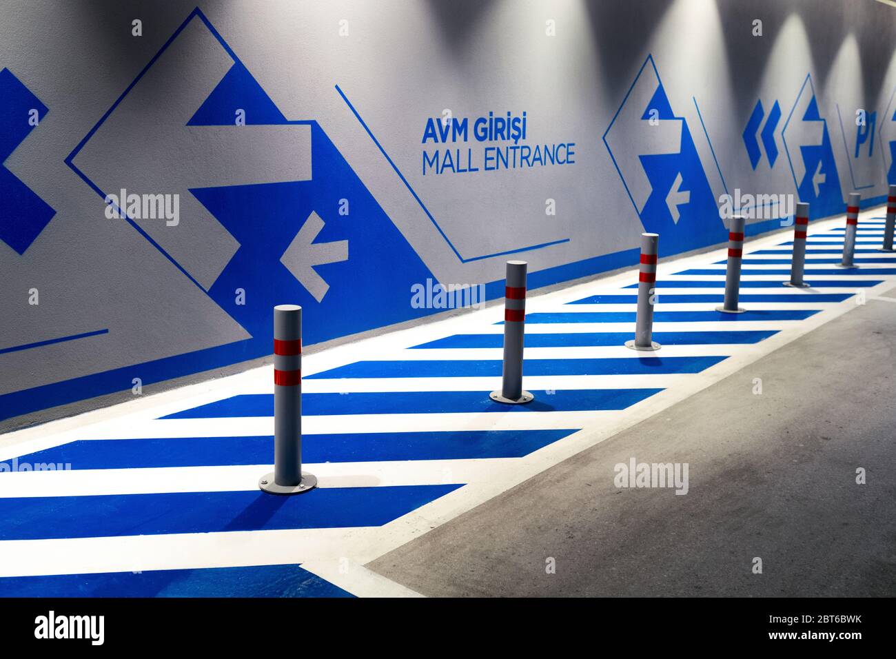 Eingang Einkaufszentrum schriftliche Wand mit Pfeilen mit blauer Farbe in einem Parkplatz eines Einkaufszentrums Stockfoto