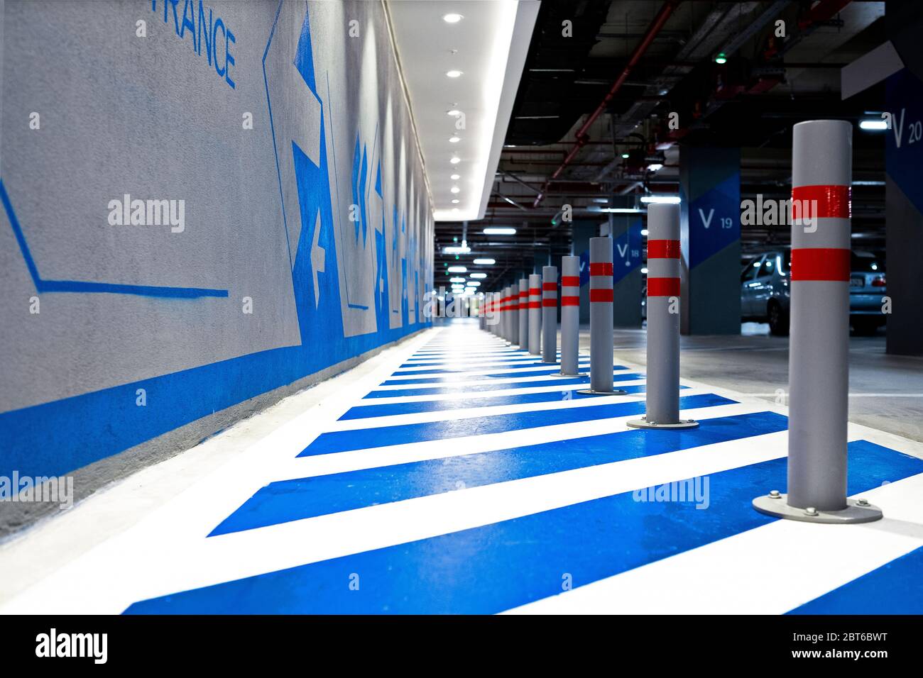 Eingang Einkaufszentrum schriftliche Wand mit Pfeilen mit blauer Farbe in einem Parkplatz eines Einkaufszentrums Stockfoto