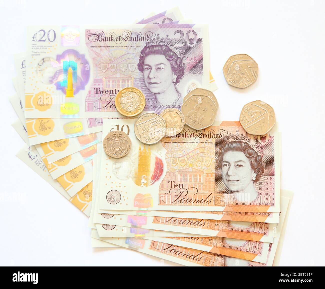 Zehn 10 und 20 britische Pfund-Banknoten und Münzen auf weißem Hintergrund Stockfoto