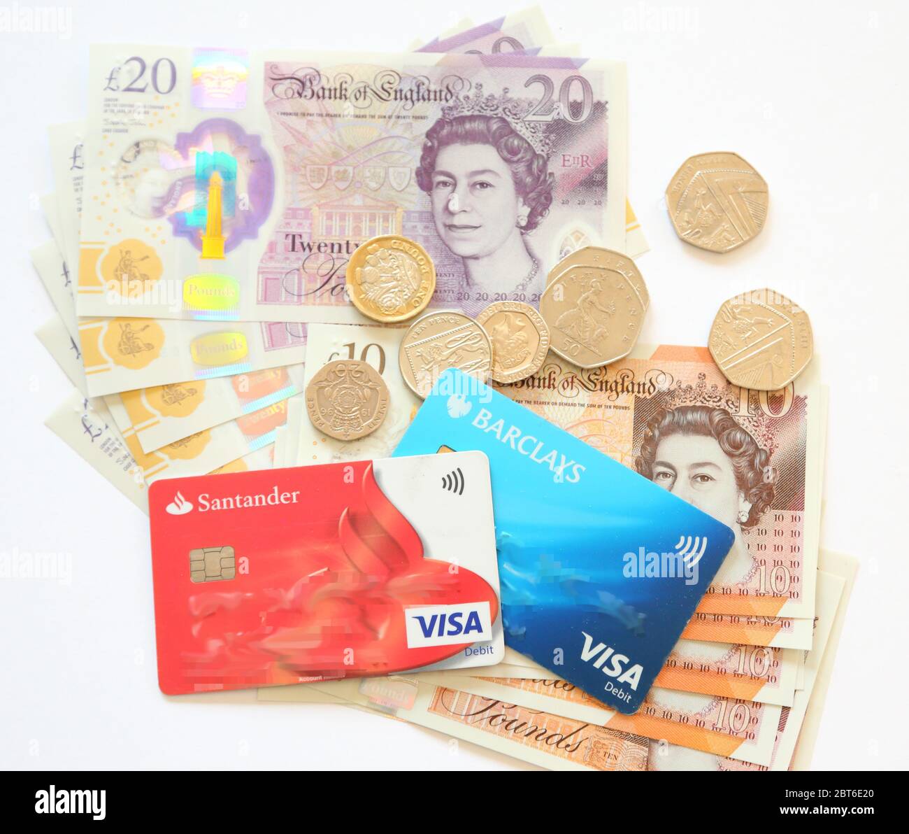 Britische Pfund-Banknoten, Debitkarten und Münzen auf weißem Hintergrund Stockfoto