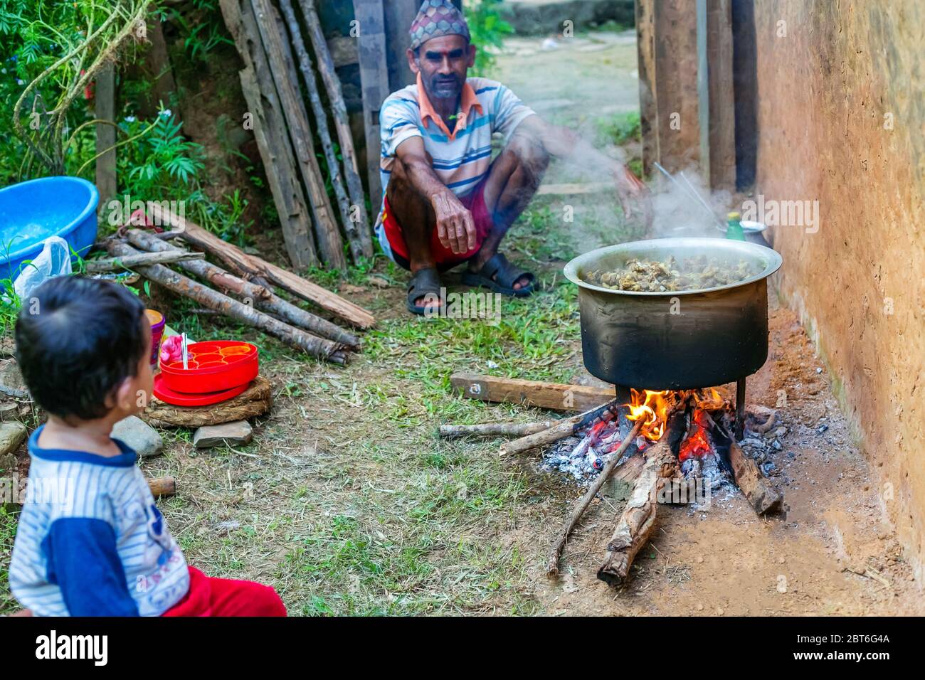 Gorkha, Nepal - Oktober 6,2019: Alter Mann kocht Mutton Curry im ländlichen Dorf Nepal. Hammelcurry.Selektiver Fokus Stockfoto