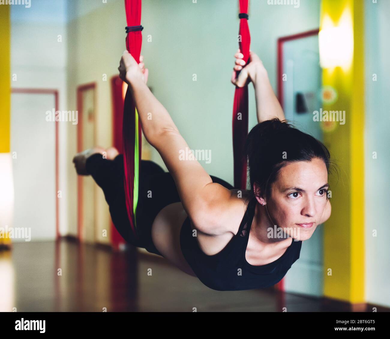 Junge Frau, die Yoga-Akrobatik in der Luft auf einer Schaukel. Konzept der Yoga-Akrobatik Stockfoto