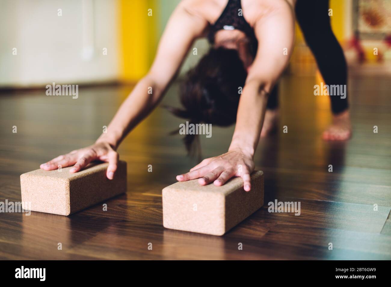 Frau, die Yoga-Übungen mit Ziegeln für Yoga macht. Konzept der Yoga-Übungen Stockfoto