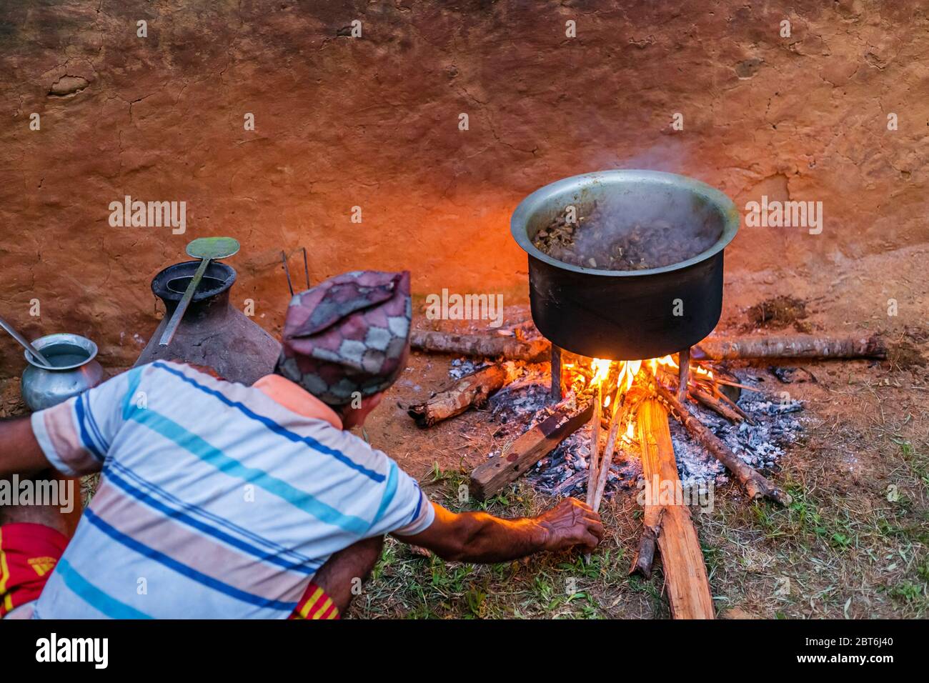 Gorkha, Nepal - Oktober 6,2019: Alter Mann kocht Mutton Curry im ländlichen Dorf Nepal. Hammelfleisch Curry Stockfoto
