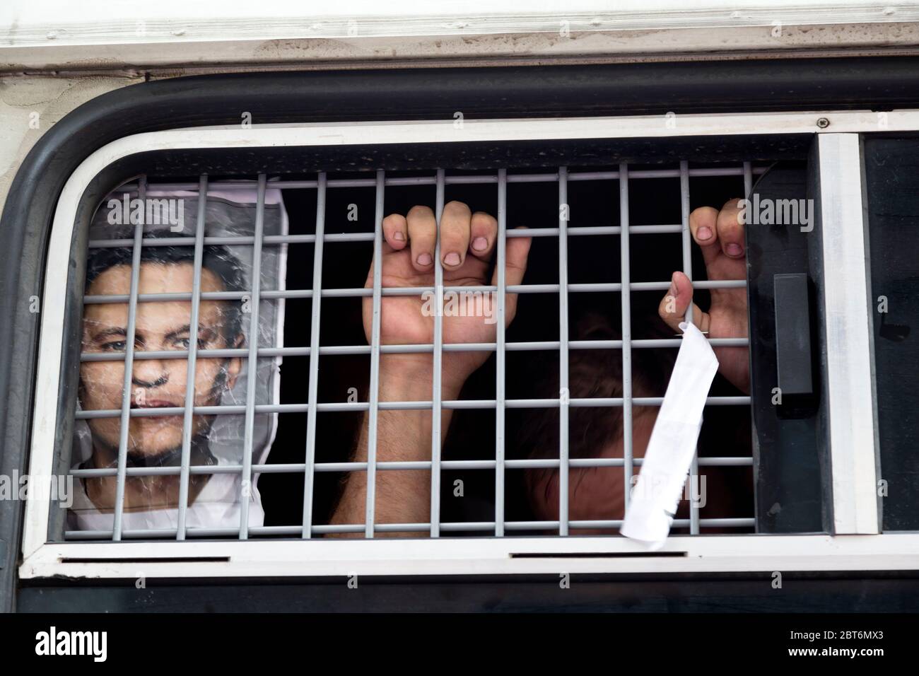 Moskau, Russland. 18. Juli 2013 Hände eines von der Polizei inhaftierten Oppositionellen und das Porträt von Alexey Navalny hinter den Gittern eines Polizeiwagen im Zentrum von Moskau Stockfoto