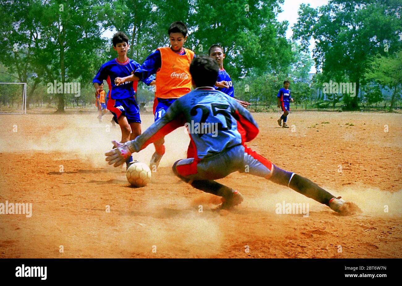 Junge indonesische Fußballspieler der SSB (Fußballschule) Tunas Patriot haben ein Spiel auf einem staubigen Feld in Bekasi, West Java, Indonesien. Archivfoto (2002). Stockfoto