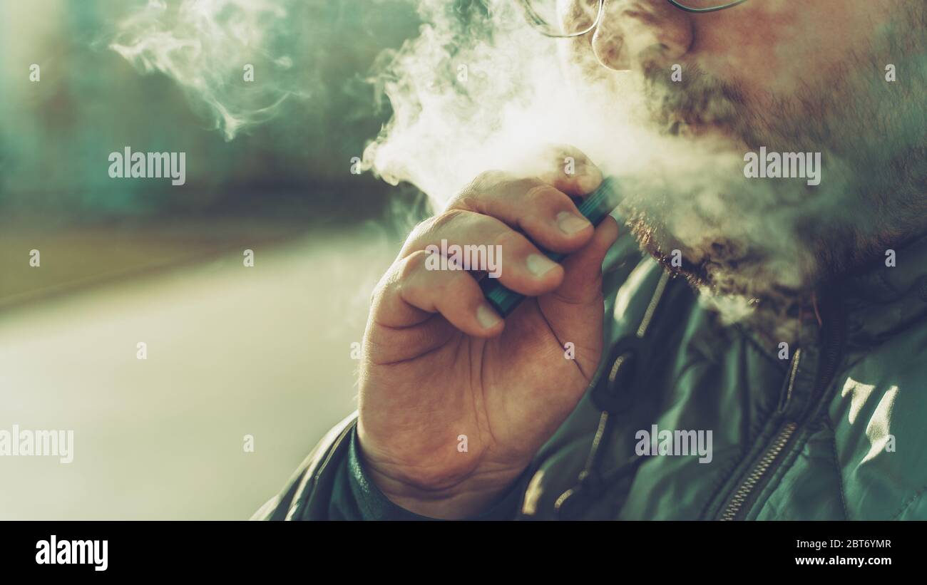 Man raucht neues Vape Pod System, atmet Dampf elektronischer Zigarette aus,  dampft Konzept, selektiver Fokus, Kopierraum Stockfotografie - Alamy