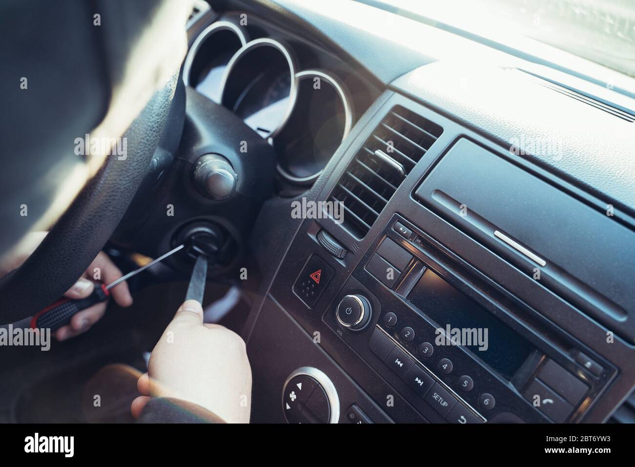 Kriminelle bricht das Auto Zündschloss zu stehlen Auto, Nahaufnahme. Konzept für Autodiebstahl, getönte Stockfoto