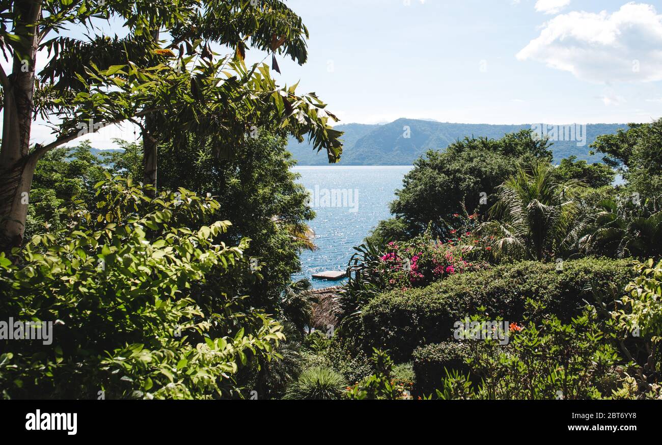 Schwimmende Plattform für Entspannung auf dem Kratersee der Laguna de Apoyo, Nicaragua, durch Bäume gesehen Stockfoto