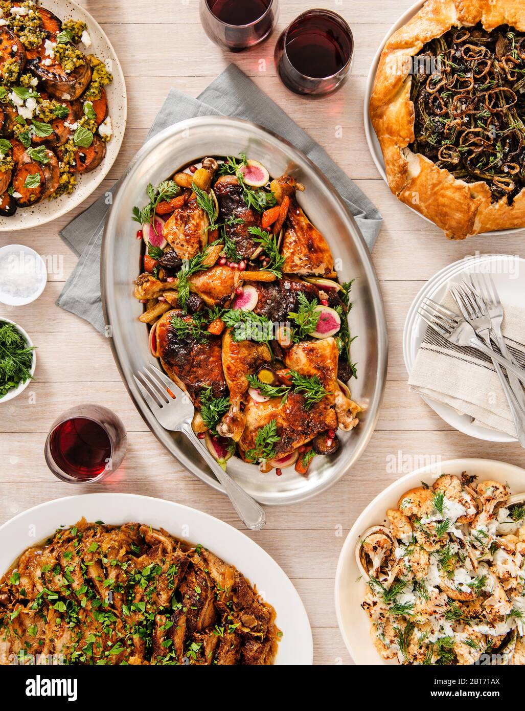 Tisch-Setting mit gebratenen Hähnchen-Beilagen und Rotwein Stockfoto