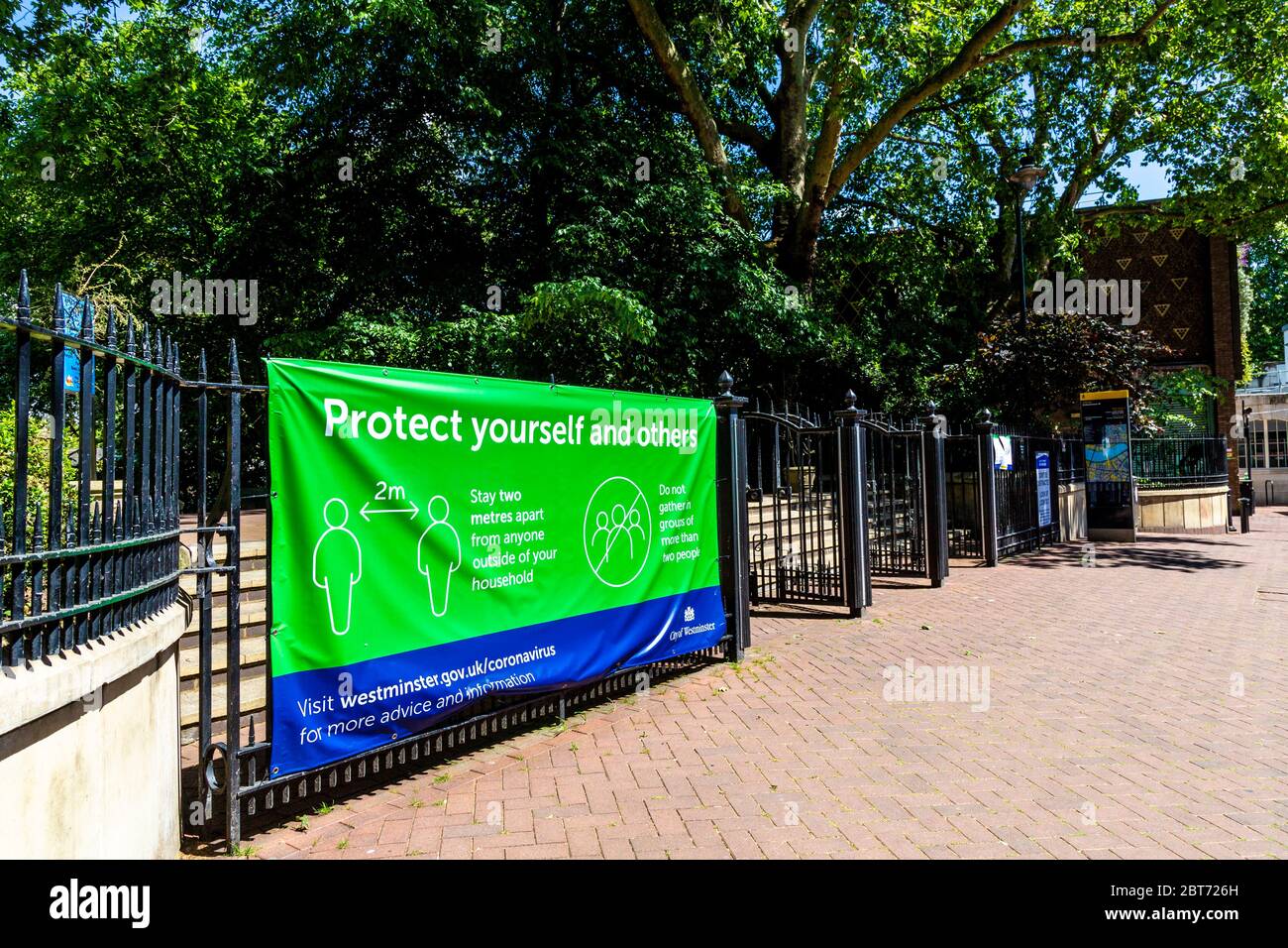21 May 2020, London, UK - Schild an den Toren der Victoria Embankment Gardens, um Menschen mit einer Entfernung von 2 Metern daran zu erinnern, die Regierungsanweisungen zur Verhinderung der Ausbreitung des Coronavirus während der Pandemiesperre zu befolgen Stockfoto