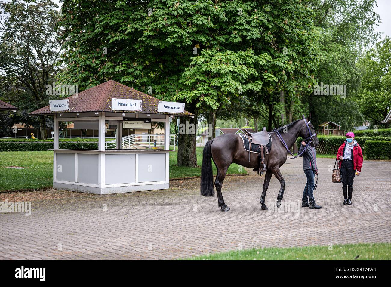 Feature, Dekorationsbild, Hintergrund, Hintergrundbild, Symbol, Symbolbild: Zwei Rennbahn-Besucher mit Schutzmasken sprechen vor einem leeren Verkaufsstand. GES/Gallop Sport/Iffezheim Spring Metting, 23. Mai 2020 23. Mai 2020 Horseracing Spring Festival, Iffezheim, 23. Mai 2020 weltweit Stockfoto