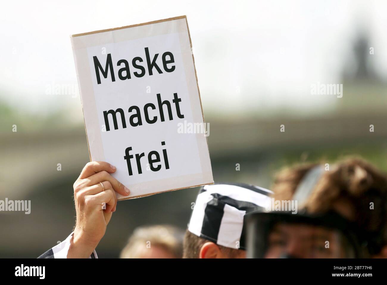 Köln, Deutschland. Mai 2020. Bei einer Demonstration gegen die Beschränkungen Corona hält ein Demonstrant in einem Häftlingsanzug ein Plakat mit der Aufschrift "Macht frei". Der Mann wurde von der Polizei kontrolliert und verließ die Demonstration, nachdem er identifiziert worden war. Kredit: David Young/dpa/Alamy Live News Stockfoto