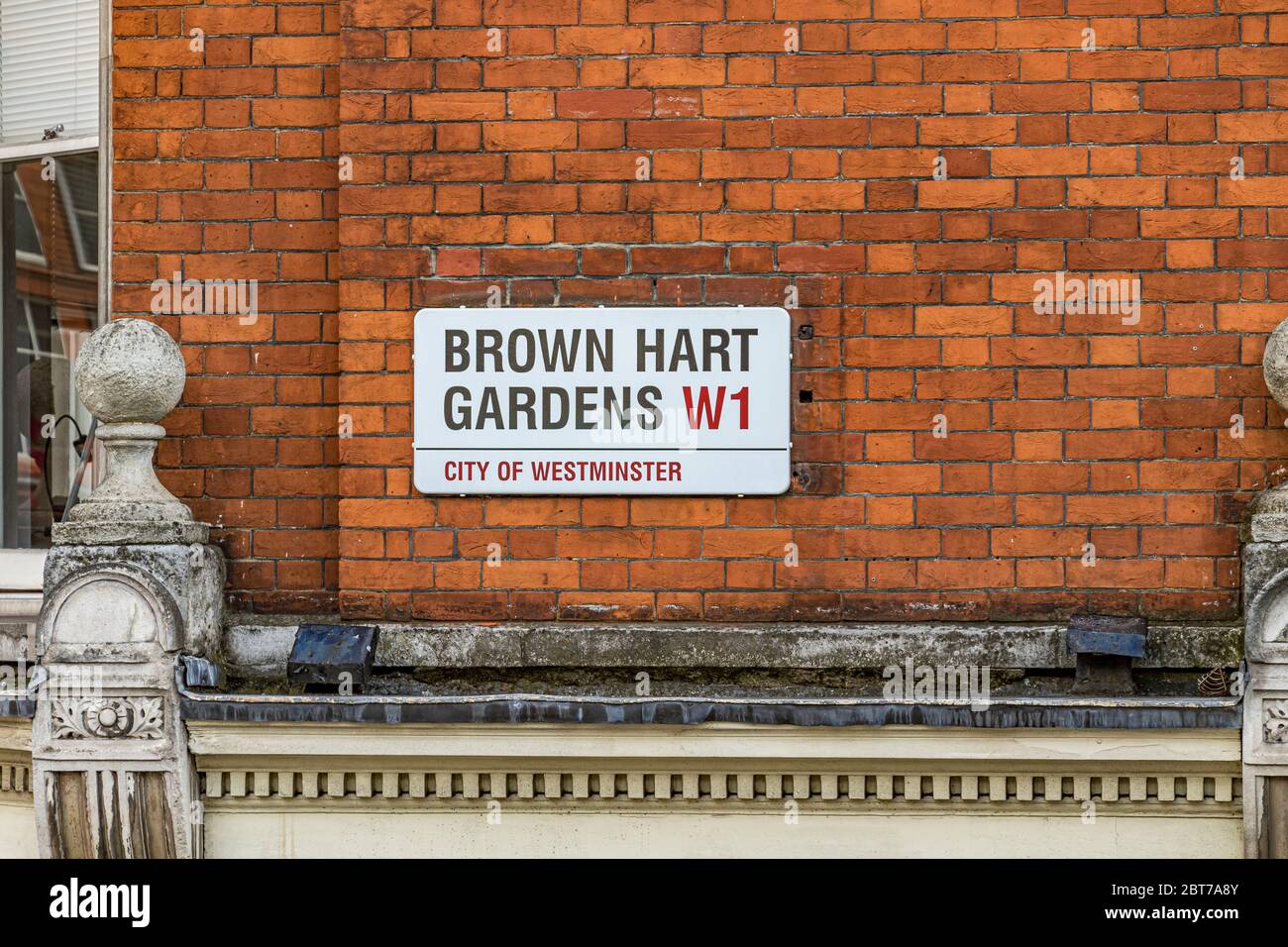 Das Straßenschild der Brown Hart Gardens hoch oben an einer roten Backsteinmauer in Mayfair, London W1 Stockfoto