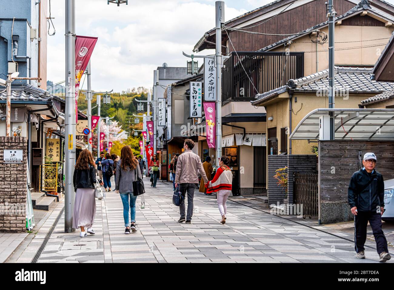 Uji, Japan - 14. April 2019: Traditionelle Dorfstadt mit Straße von Geschäften, die grüne Teepalate verkaufen und viele Touristen Touristen Ausländer zu Fuß Stockfoto