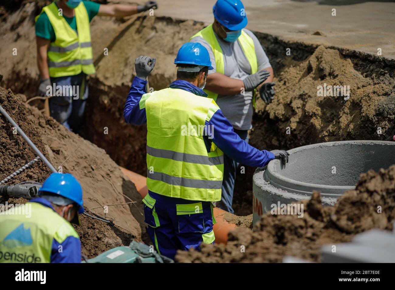 Bukarest, Rumänien - 8. Mai 2020: Bauarbeiter auf einer Baustelle mit Schutzmasken wegen des Ausbruchs von Covid-19. Stockfoto