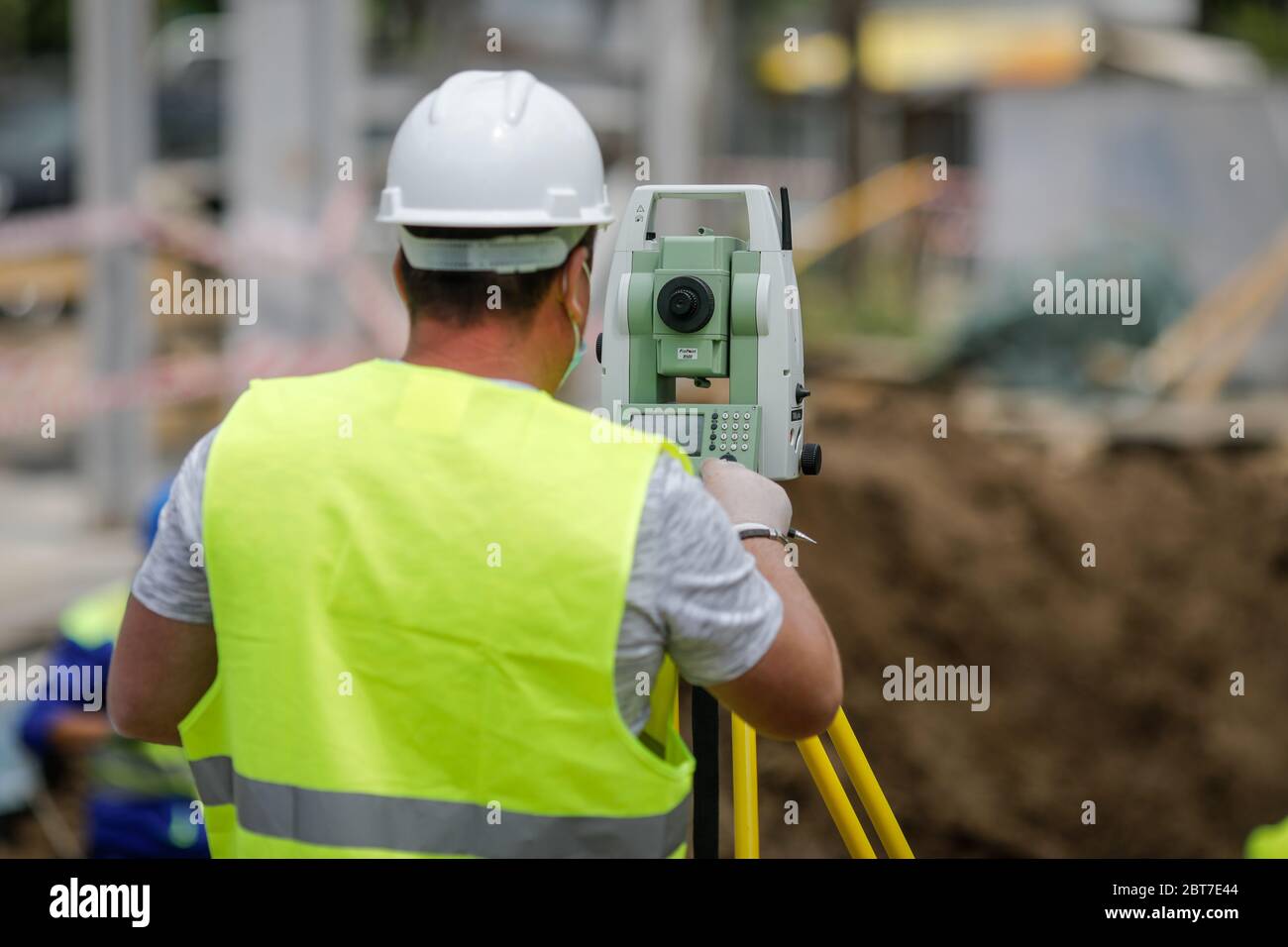 Bukarest, Rumänien - 8. Mai 2020: Topographie-Ingenieure auf einer Baustelle mit Schutzmasken wegen des Covid-19-Ausbruchs. Stockfoto