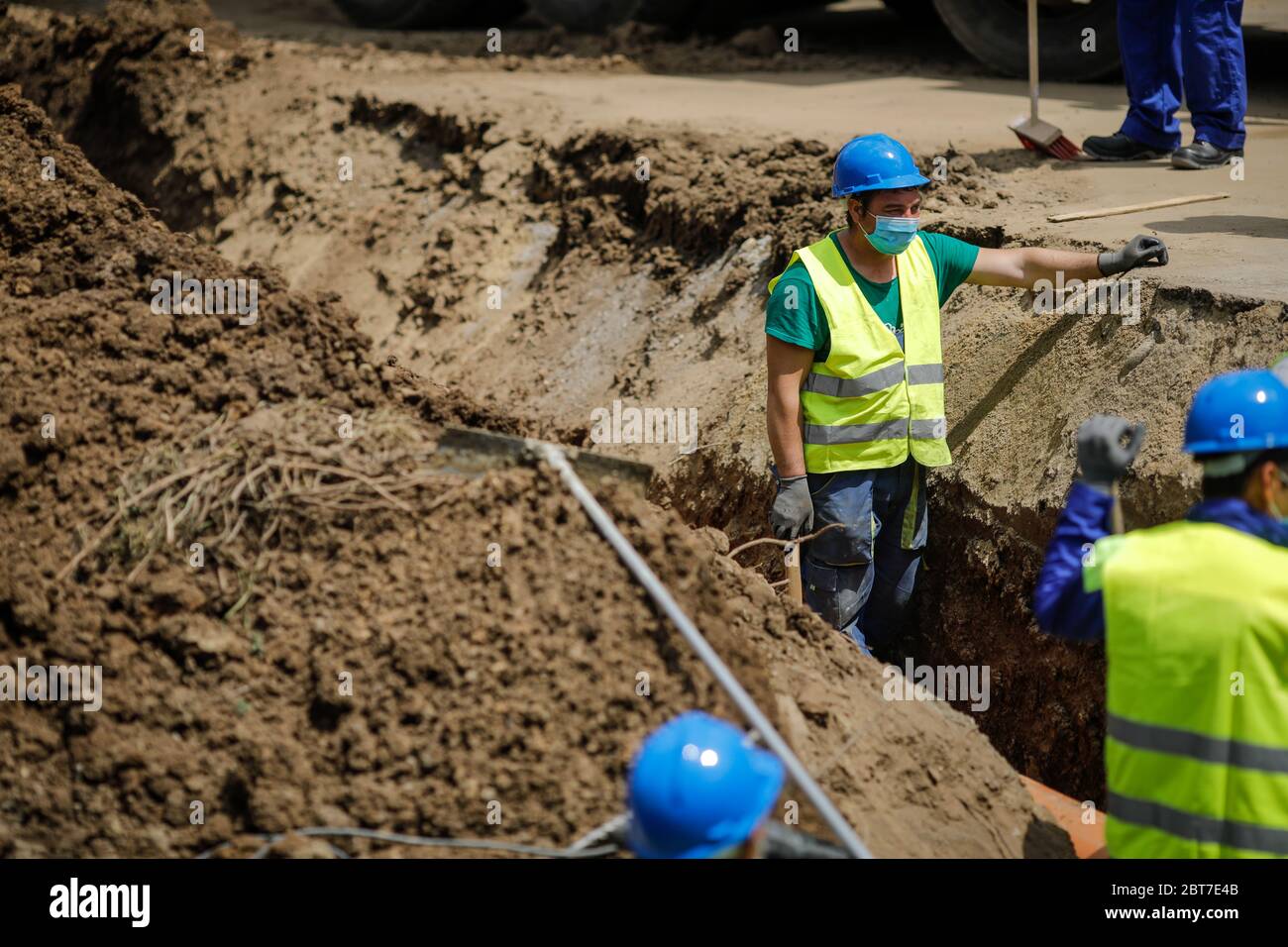 Bukarest, Rumänien - 8. Mai 2020: Bauarbeiter auf einer Baustelle mit Schutzmasken wegen des Ausbruchs von Covid-19. Stockfoto