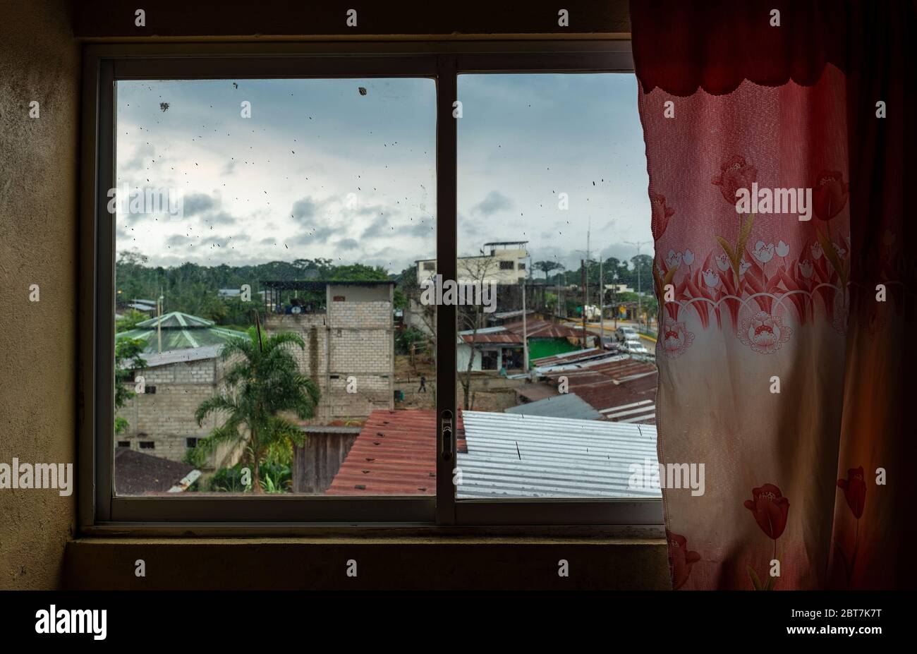 Stadtbild der Stadt Lago Agrio (durch ein schmutziges Fenster) im Amazonas-Regenwald und Tor zum Cuyabeno Wildlife Reserve, Ecuador. Stockfoto